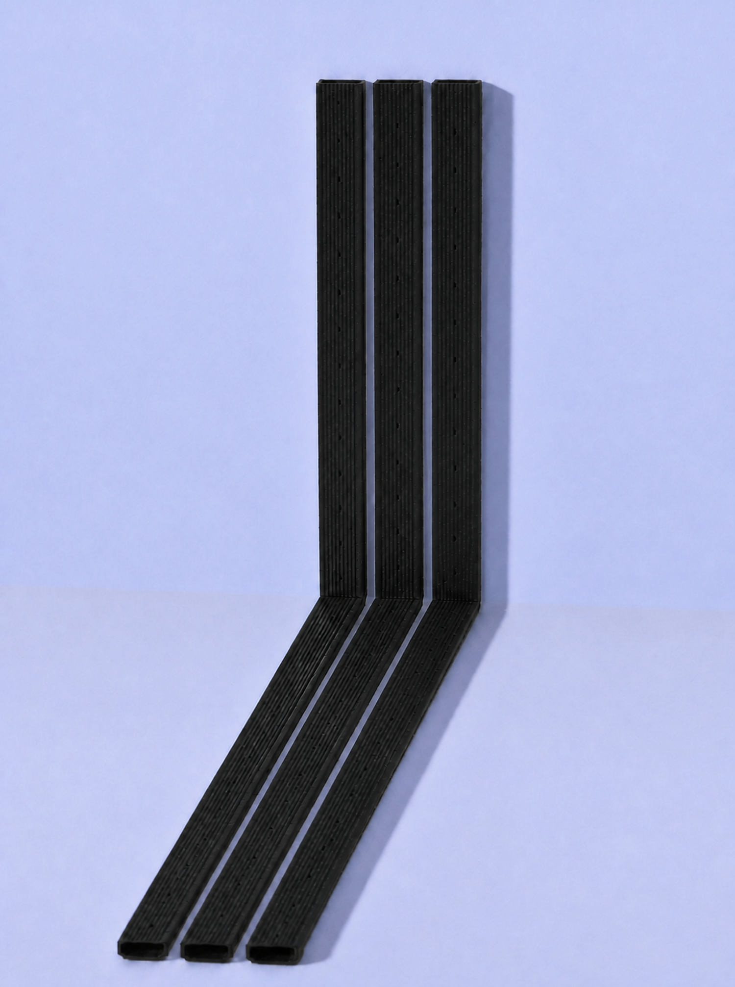 Three production AlphaTherm Pro warm-edge spacer frames showing open profile ends, formed bends and diagonal sections